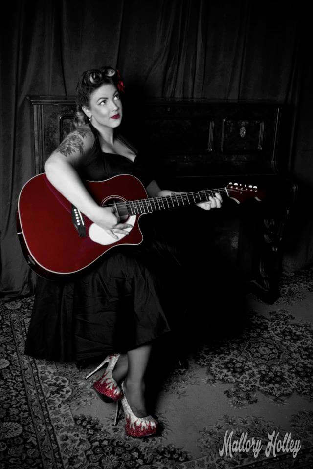 Pinup beauty Miss Laura playing fender guitar